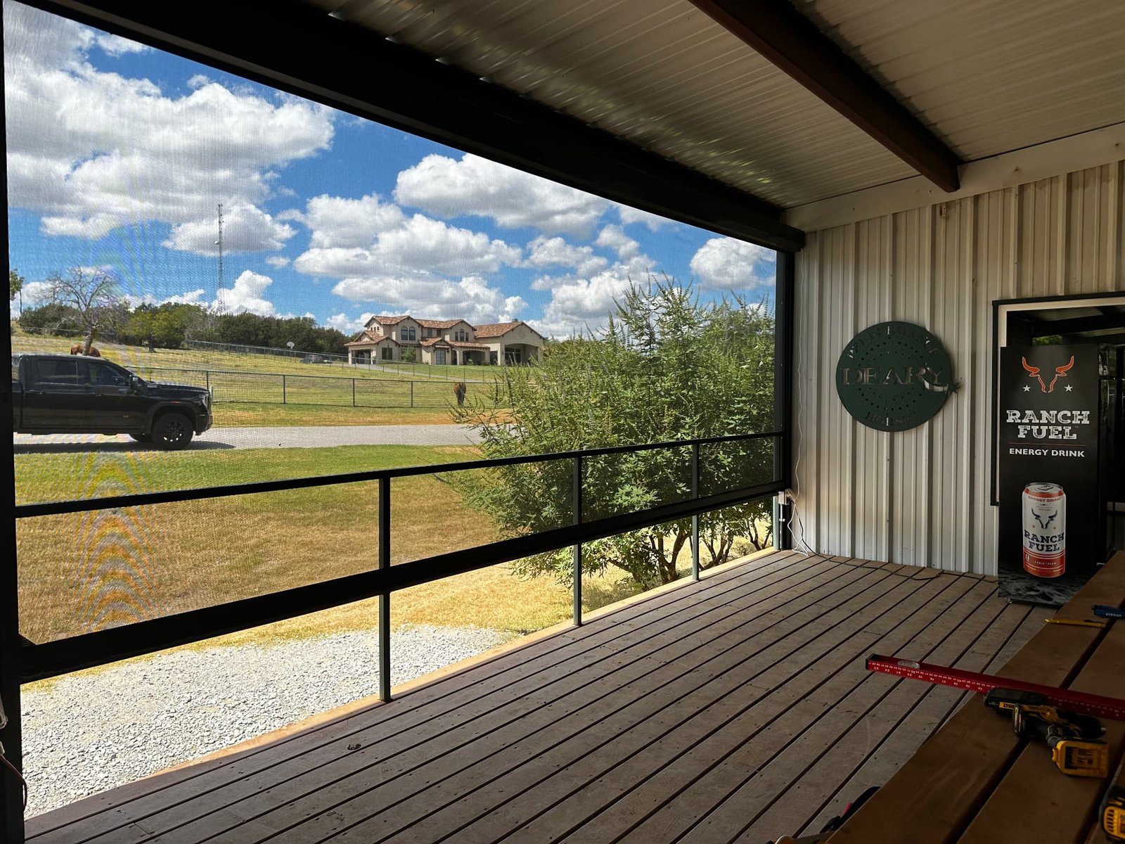 Retractable screens on a Texas ranch building viewed from a different angle, combining shade and insect protection with an open view of the property.