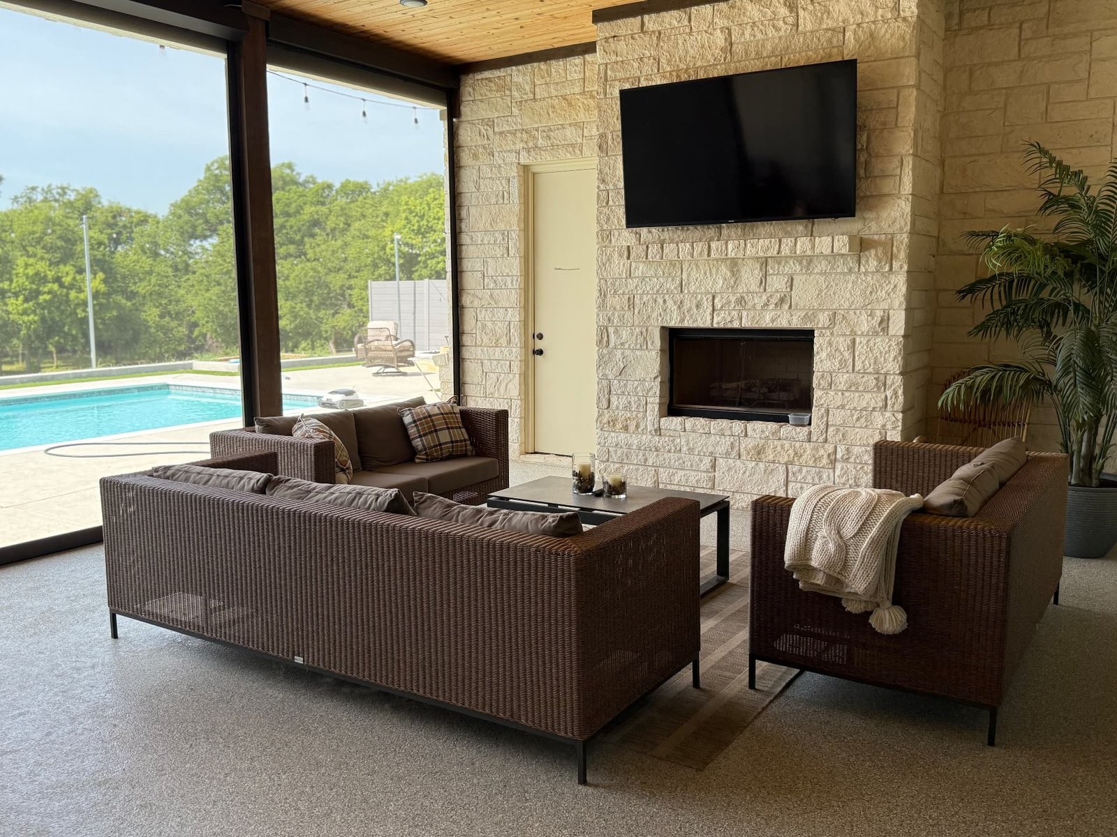 Motorized insect screens fully lowered on a covered Texas outdoor living space, helping provide shade, privacy and protection from insects.
