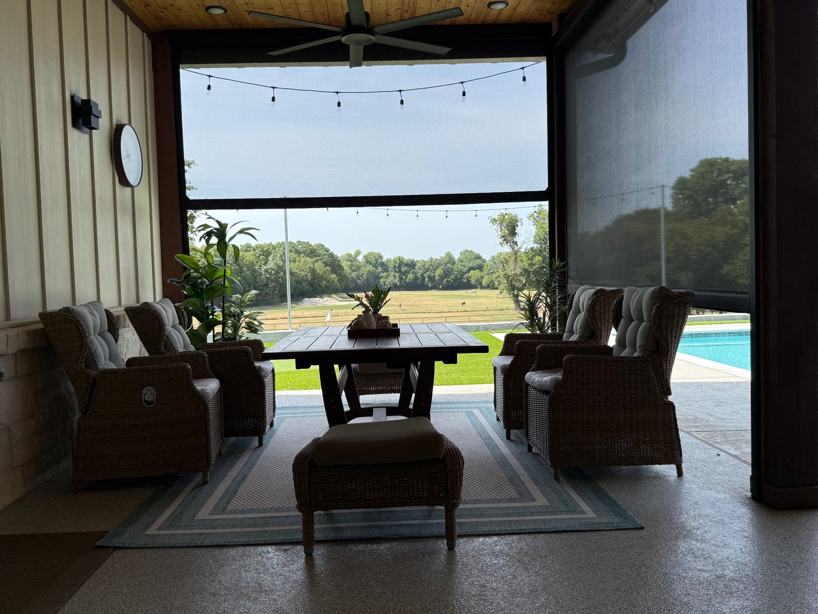 Motorized retractable patio screens partially lowered on a covered Texas patio, providing shade while keeping the outdoor view open.