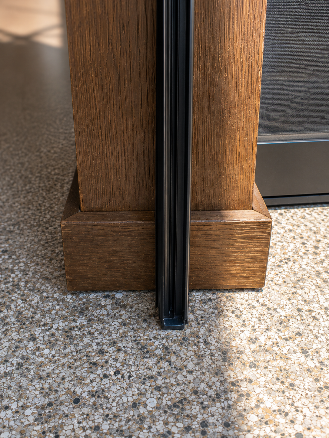 A floor track disappearing flush into natural stone.